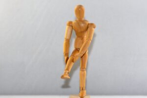 Wooden Figure with Knee Pain